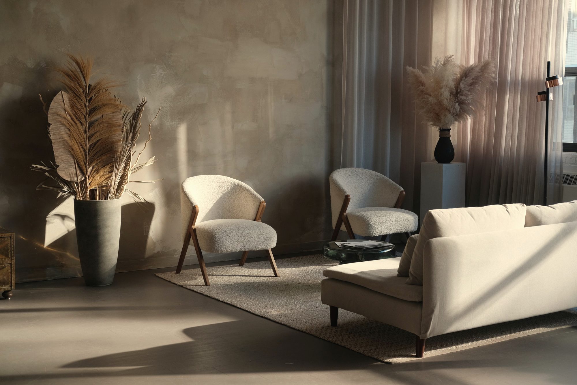 Cream sofa and bouclé chairs in low sun